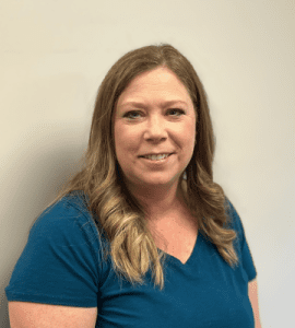 Portrait of Cherry Martini, Controller at Oriol Health Care, smiling in a teal top against a neutral background.