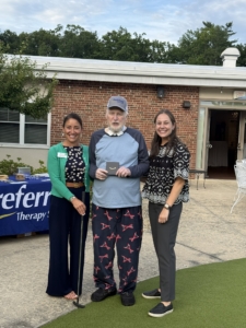 Putting Contest Winner Winner of the Swing Into Wellness putting challenge receives their prize at Holden Rehabilitation & Skilled Nursing Center.