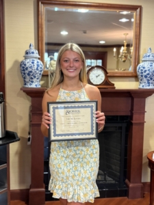 Lily Leroux holds her certificate after receiving the 2026 Eugene Oriol Memorial Community Scholarship from the Oriol Foundation.
